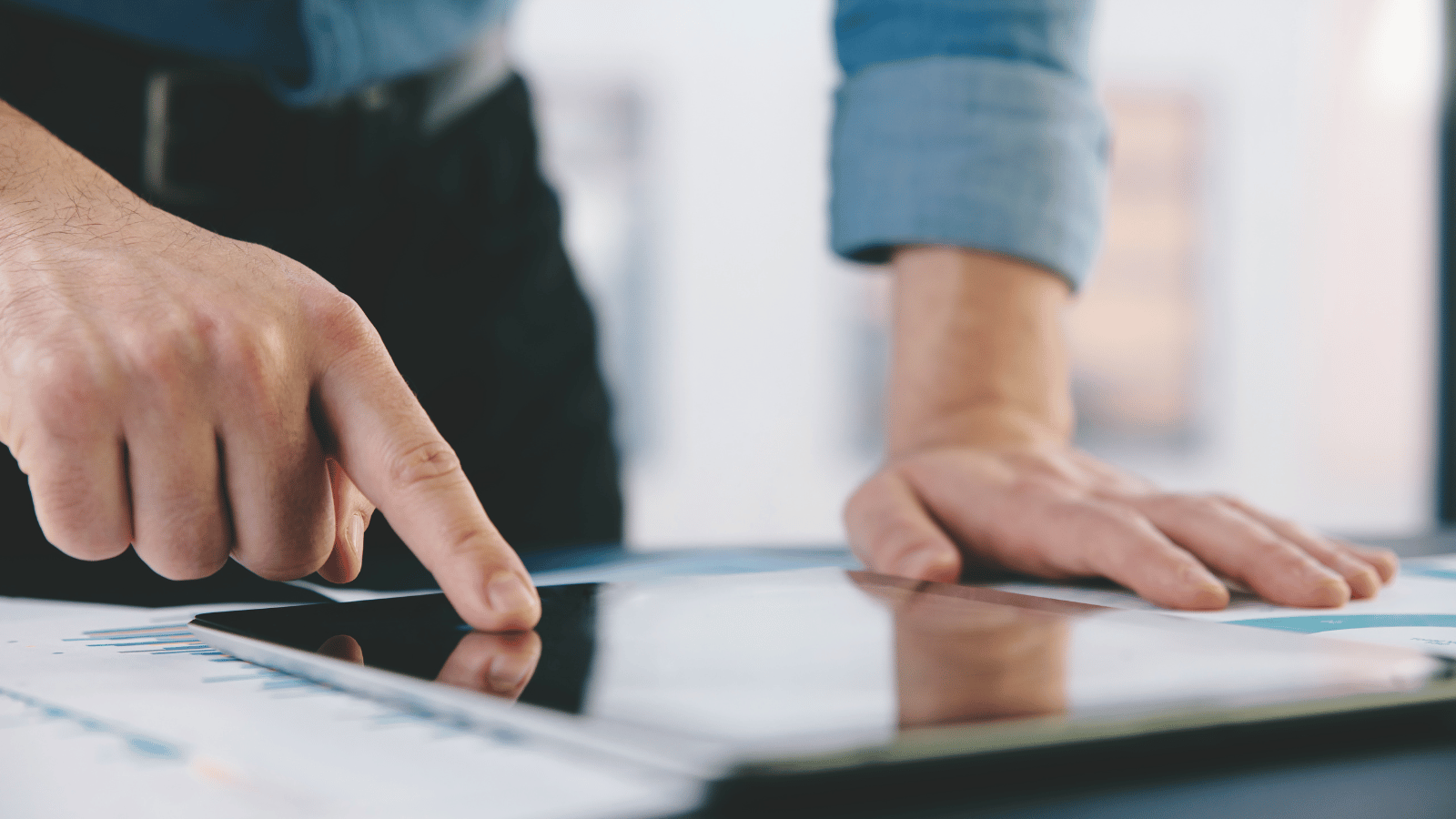 Man looking at iPad that is laid on his desk